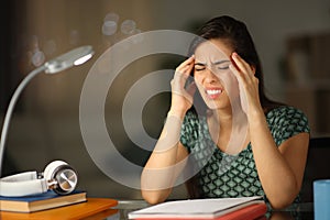Stressed student suffering head ache in the night