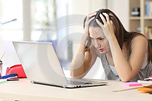 Stressed student memorizing on laptop studying at home photo