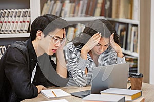 Stressed students preparing for examination in library