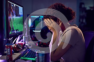 Stressed Teenage Girl Being Bullied Online Whilst Gaming At Home