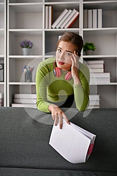 Stressed and thoughtful Asian businesswoman leaning on sofa with serious expression