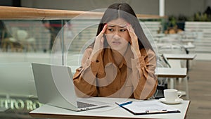 Stressed tired Asian woman working in cafe with laptop paperwork problem business difficulty sick unhealthy chinese