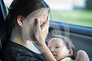 Stressed tired mother suffering from postpartum depression, holding her baby photo