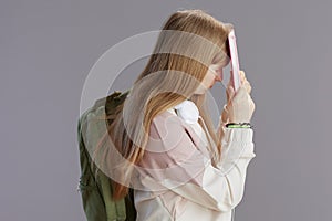 stressed trendy teenage girl in beige tracksuit with backpack