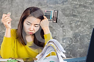 Stressed unemployment Asian woman hand holding one coin and calculator having problem with financial crisis, bankruptcy during