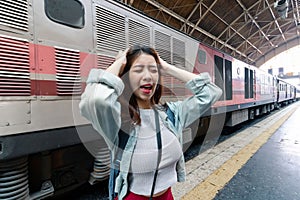 Stressed upset young Asian backpacker feeling shock and depression after miss a train. Problem and travel lifestyle concept
