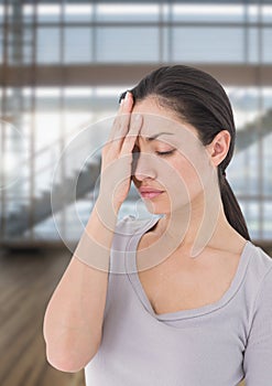 Stressed woman against bright windows