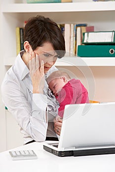 Stressed Woman With Baby Working From Home