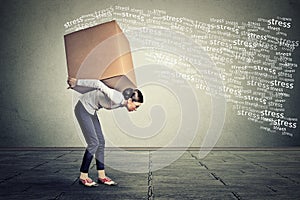 Stressed woman carrying on her back large box