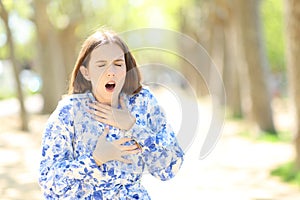 Stressed woman choking in a park