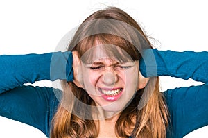 Stressed woman covering her ears to protect from loud noise