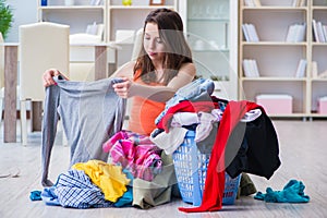 The stressed woman doing laundry at home