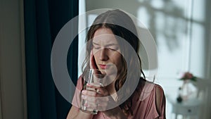 Stressed woman drinking water at night closeup. Worried sick girl suffering pain