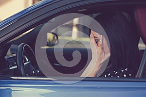 Stressed woman driver sitting inside her car