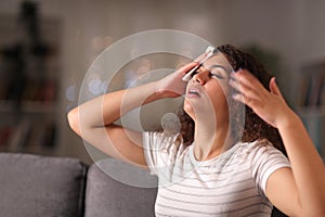 Stressed woman drying sweat in a warm night at home photo