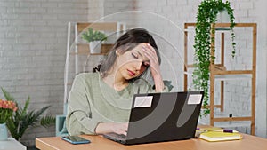 Stressed woman feeling tired worried about work problem looking at laptop screen.