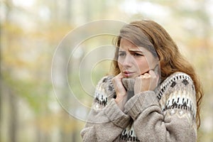 Stressed woman getting cold in winter in a park