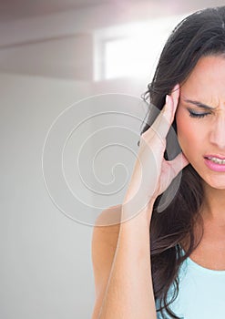 Stressed woman with headache against window light