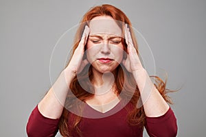 Stressed woman with headache holding her hands on head