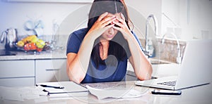 Stressed woman looking down at bills