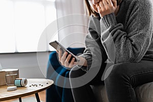 stressed woman with medicine and phone at home