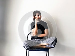 Stressed woman sitting on chair,raise finget touch her head ,thinking something serious, with upset and unhappy feeling,depressive