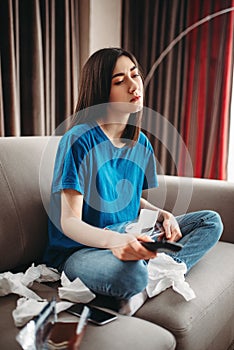 Stressed woman sitting on couch and eats chocolate