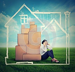 Stressed woman sitting on the ground green grass with many boxes