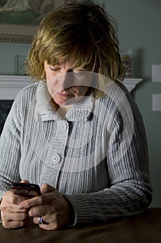 Stressed woman texting on a cell phone