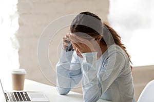 Stressed woman at work putting hand on her forehead