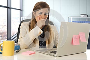 Stressed woman working with laptop computer on desk in overworked