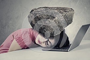 Stressed worker with a burden on her head photo