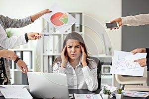 Stressed worker with a lot of work sitting at table in office