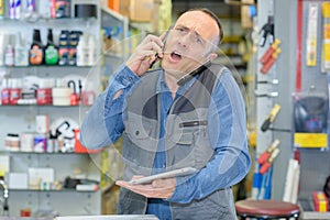 Stressed worker on phone in hardwarehouse