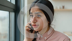 Stressed worried Indian Arabian businesswoman speak mobile phone talking negotiate cellphone annoyed angry woman girl