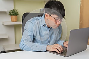 Stressed young Asian businessman, man looking, gazing computer laptop when dizziness, blurry vision on overworked, studying,