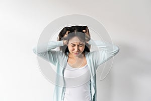 Stressed young Asian woman suffering on depression. Lady suffer from migraine and headache standing over white background