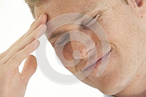 Stressed young businessman with hand on forehead