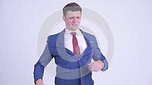 Stressed young businessman having back pain