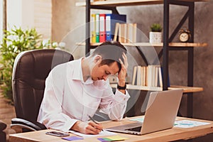 Stressed young businessman shocked by bad news using laptop at work, desperate bankrupt investor lost money, financial problem