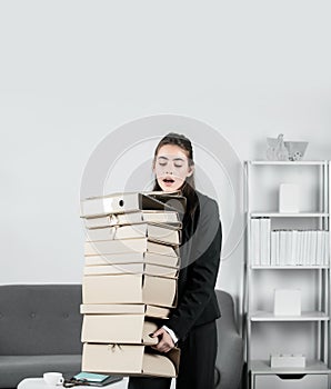 Stressed young businesswoman with folders of documents. Job, occupation and overworking concept. Successful female
