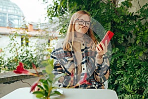 Stressed young caucasian woman having problem with not working smartphone or tablet in coffee shop cafe. Unhappy worried