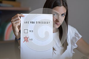 Stressed young employee or student: to a questionnaire she replies that she is not stressed but lies photo