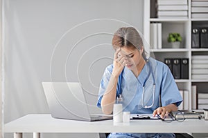 Stressed young female doctor looking at laptop reading bad news online worried of mistake at workplace. Unhappy