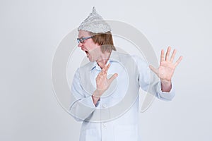 Stressed young man doctor with tinfoil hat looking scared