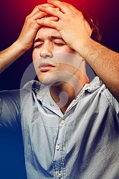 Stressed young man suffering from headache or hangover