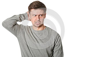 Stressed young man with uncertain puzzled expression, on white background