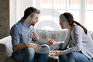 Stressed young married family couple arguing, blaming each other.