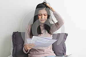 Stressed young woman calculating monthly expense and checking credit card bills invoice
