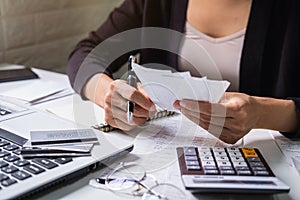 Stressed young woman checking bills, taxes, bank account balance and calculating expenses in the living room